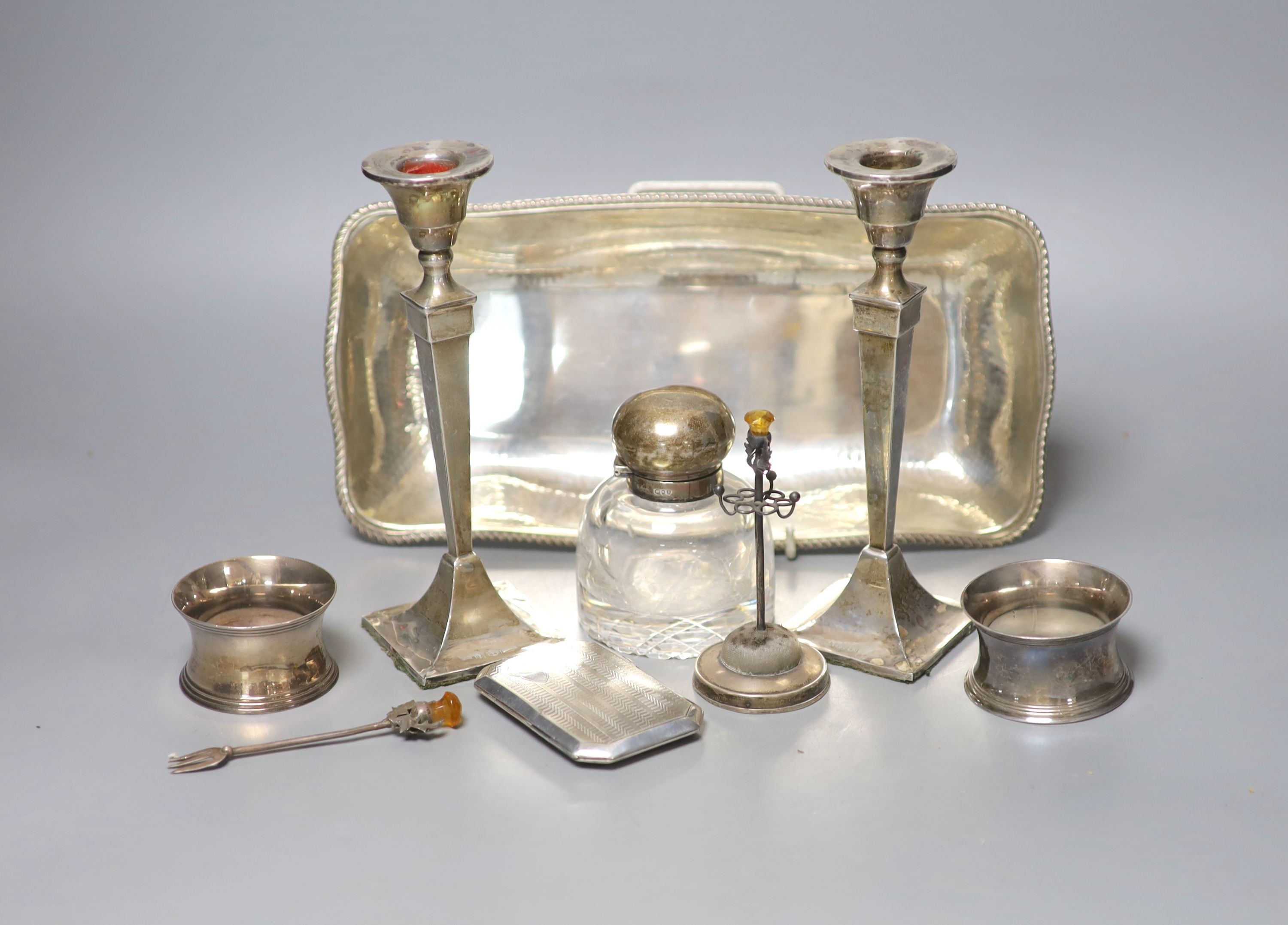 A pair of George V silver candlesticks (a.f.) and other small silver including a hat pin stand, cigarette case and 800 dish etc. and a pair of plated napkin rings.